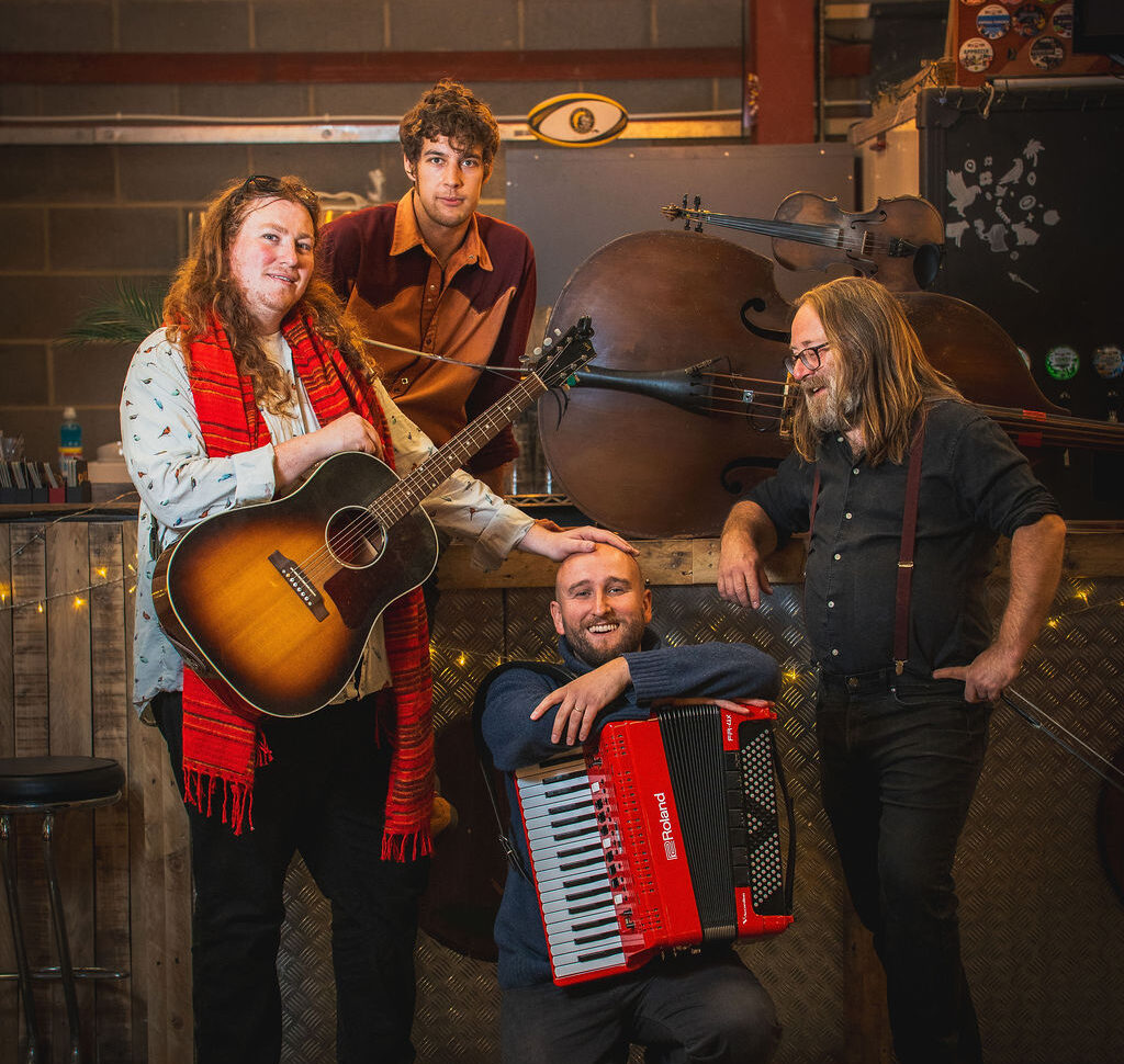 A group of musicians stand with instruments