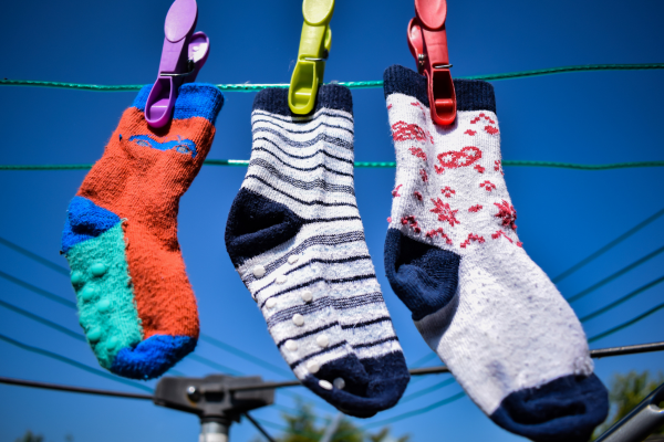 Three colourful odd socks hung up on a washing line