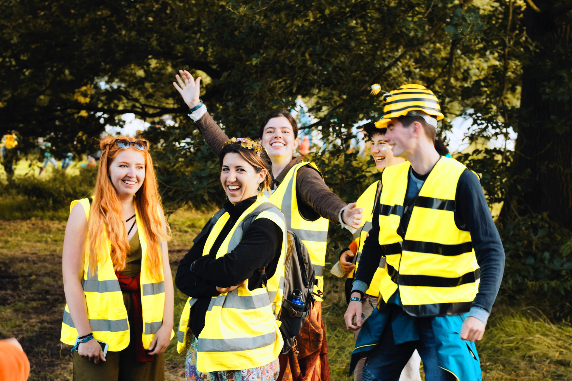 A group of smiling festival stewards stand outside wearing high vis vests.