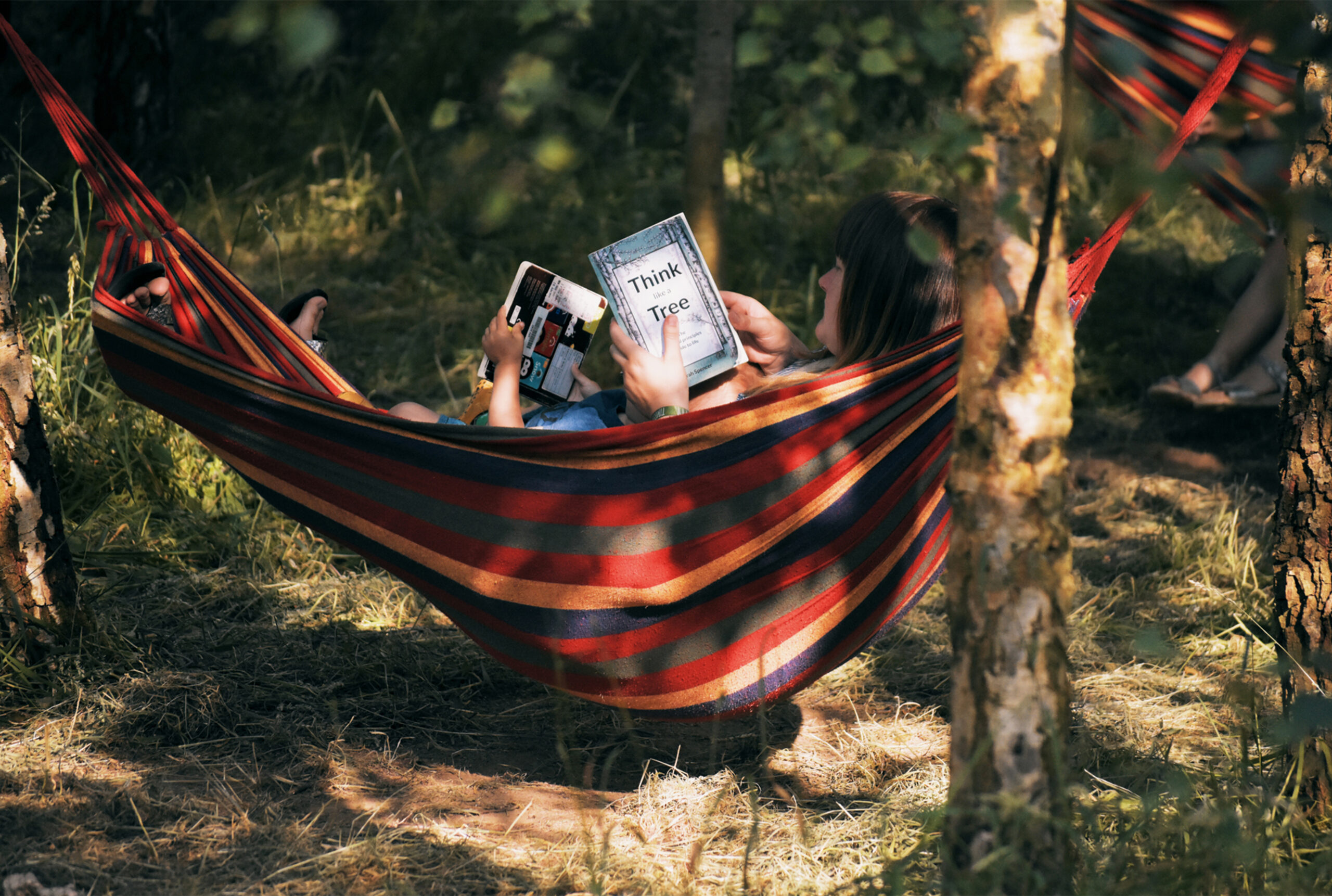 A festival goer relaxes in a hammock suspended between two trees.