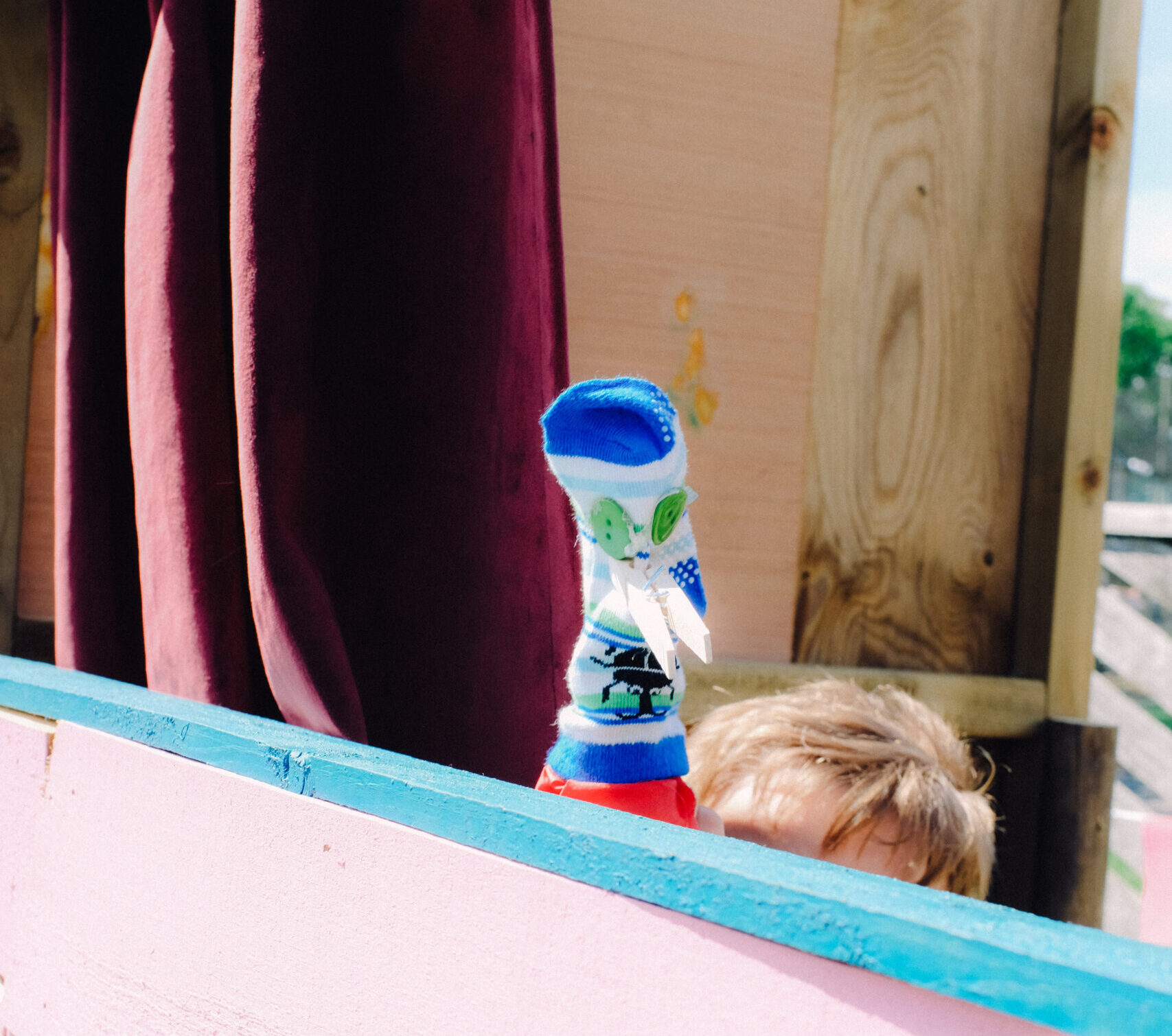Child holding a sock puppet at a puppet theatre